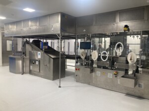 Line for filling and packing pouches under isolator